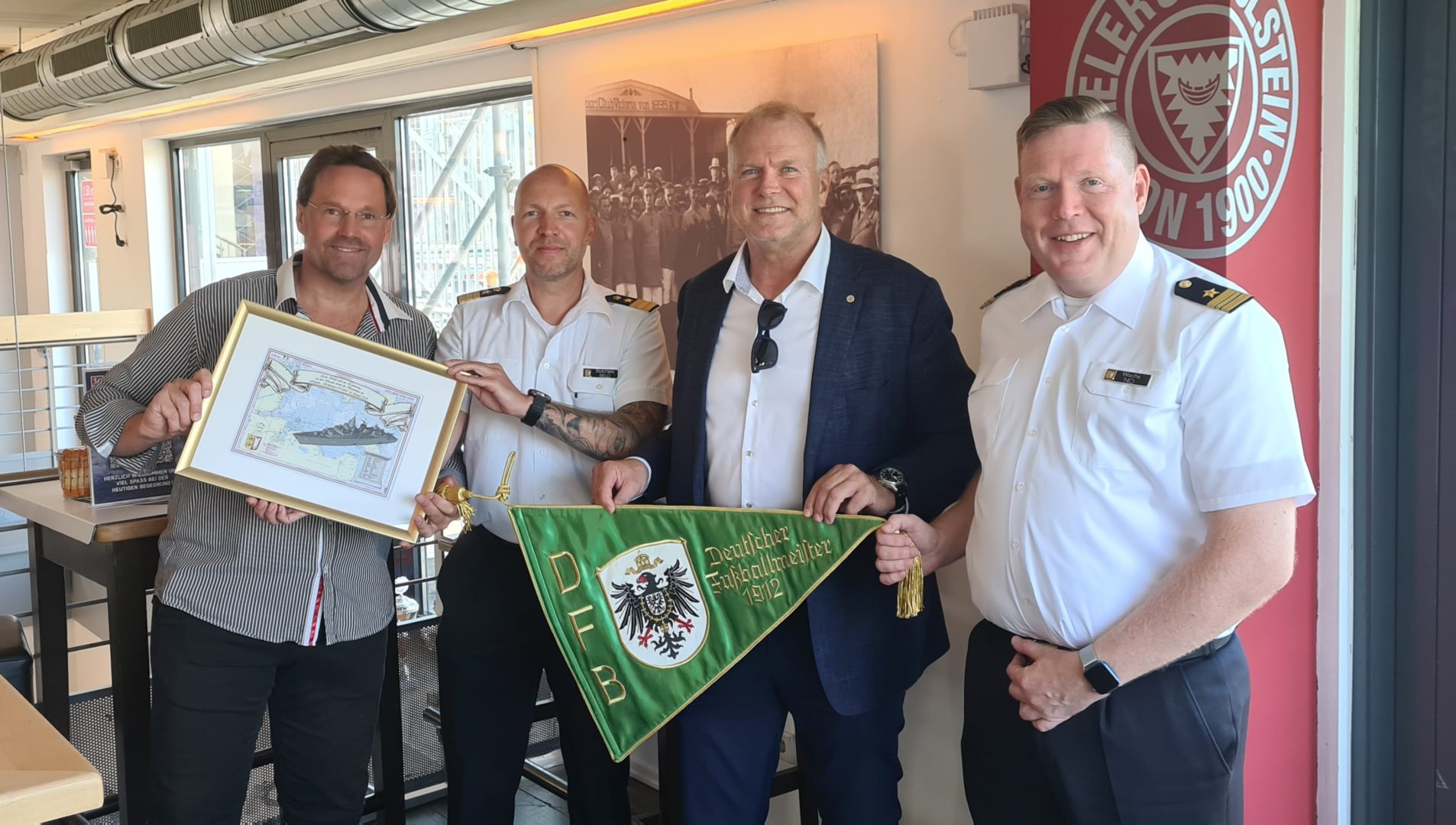 Die Schleswig-Holstein-Crew zu Besuch bei der KSV: Holsteins Club-Historiker Patrick Nawe, Korvettenkapitän Björn Borchers, Holsteins kfm. Geschäftsführer Wolfgang Schwenke und Kapitänleutnant Alexander Wachs.