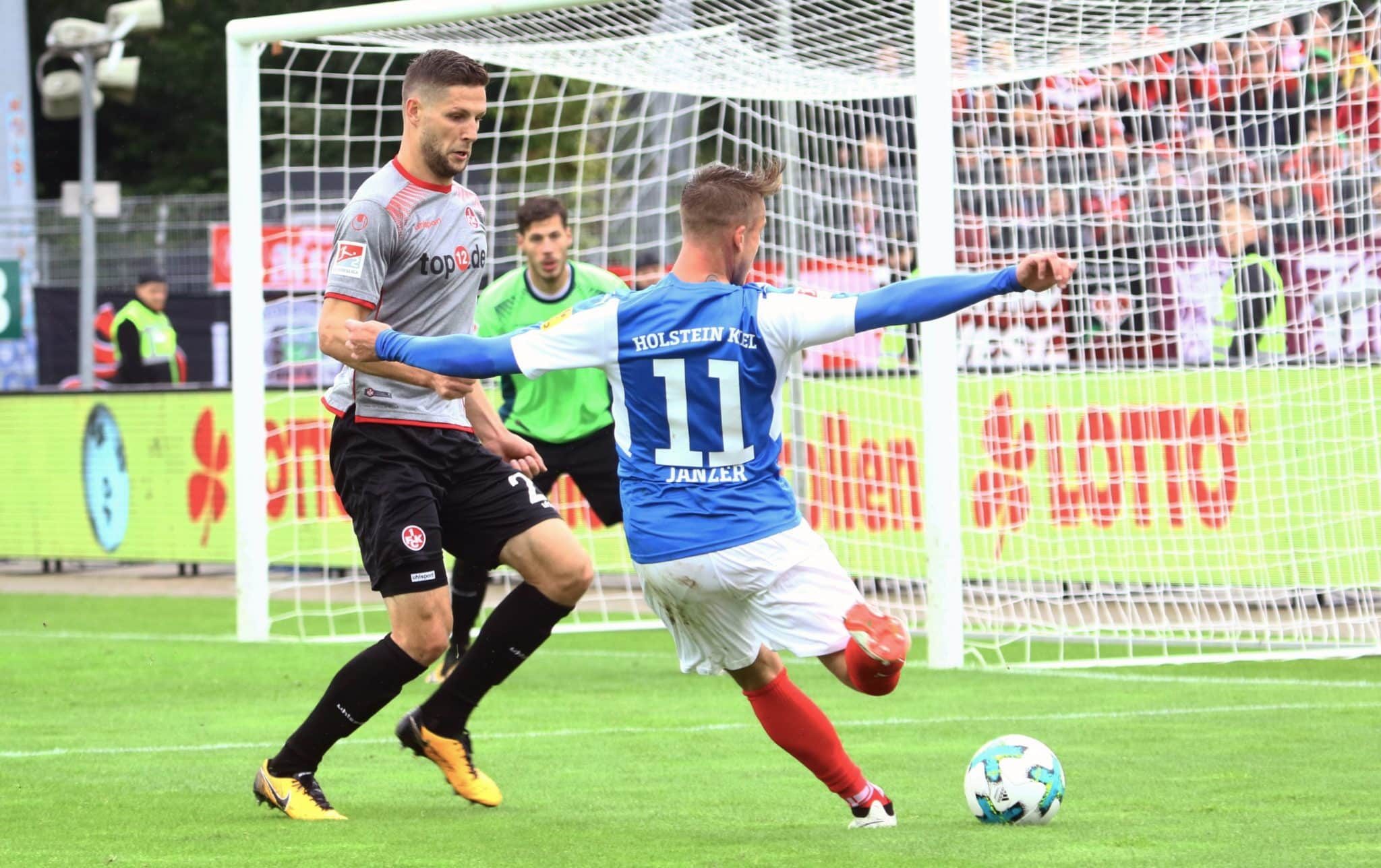 Holsteins Manuel Janzer (re.) erzielt in der Nachspielzeit den 2:1-Siegtreffer. Sein Gegenspieler Stipe Vucur (li.) und Keeper Marius Müller sind machtlos.
