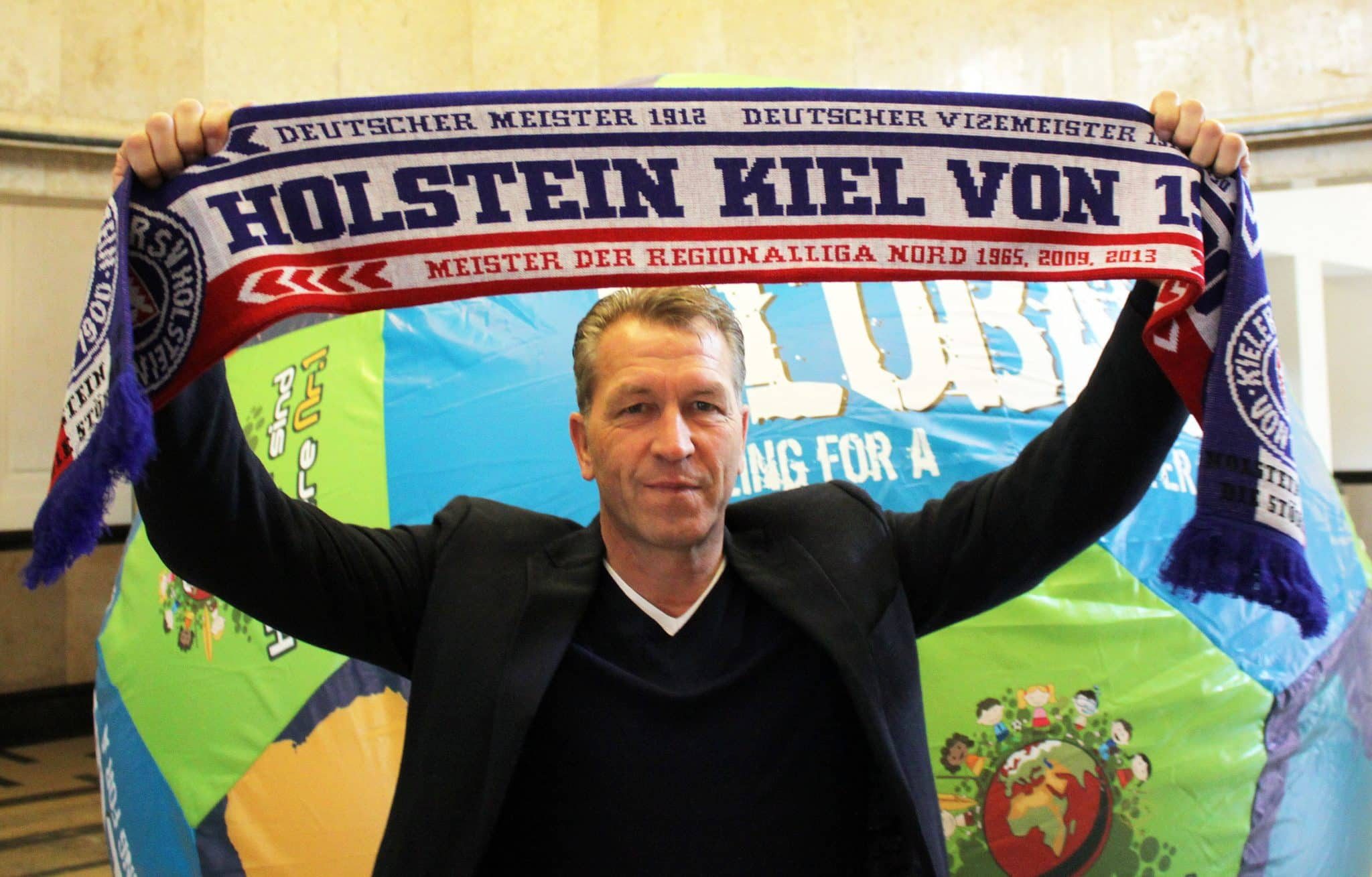 Bundes-Torwarttrainer und Ex-Storch Andreas Köpke mit Holstein Kiel-Schal im Rathaus
